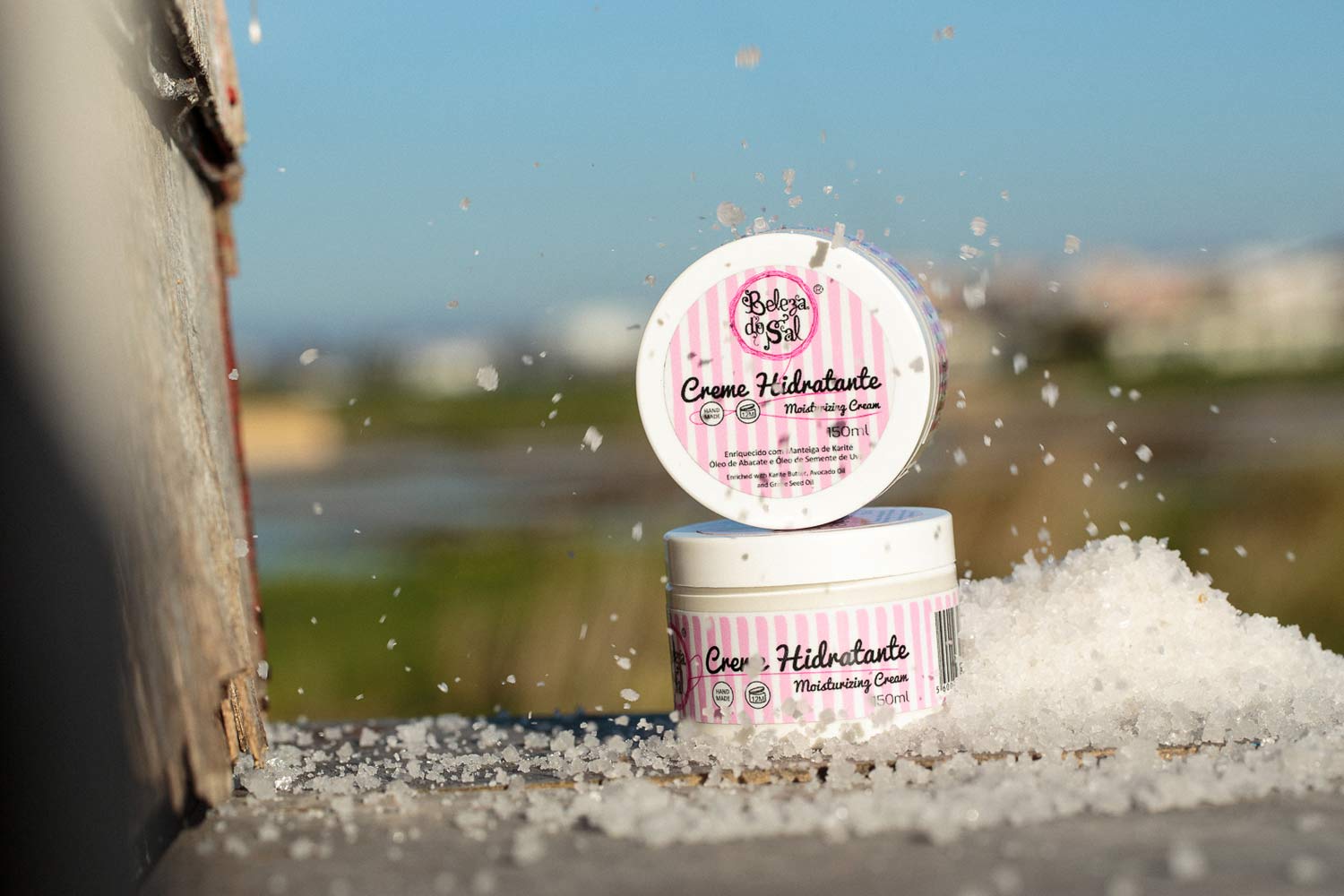 Embalagens de creme hidratante junto a monte de sal