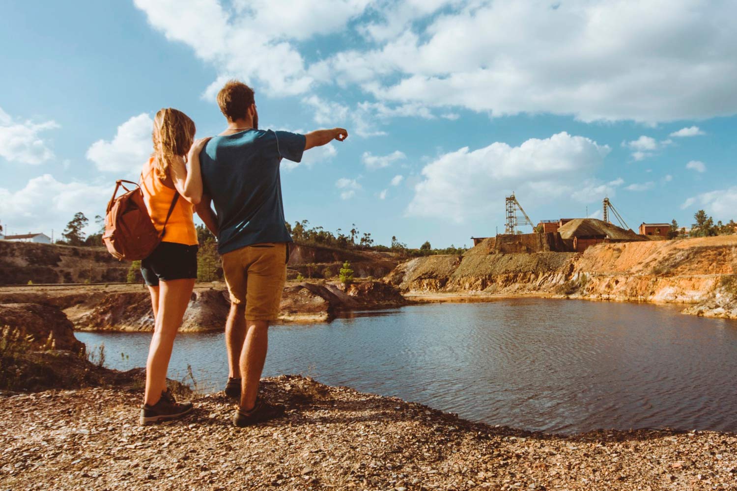  couple by a lake pointing to a Ciência Viva Centre 