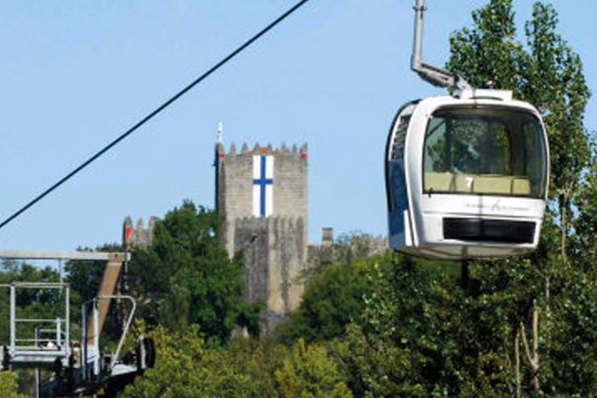  image of a cable car cabin with the Guimarães Castle tower in the background. 