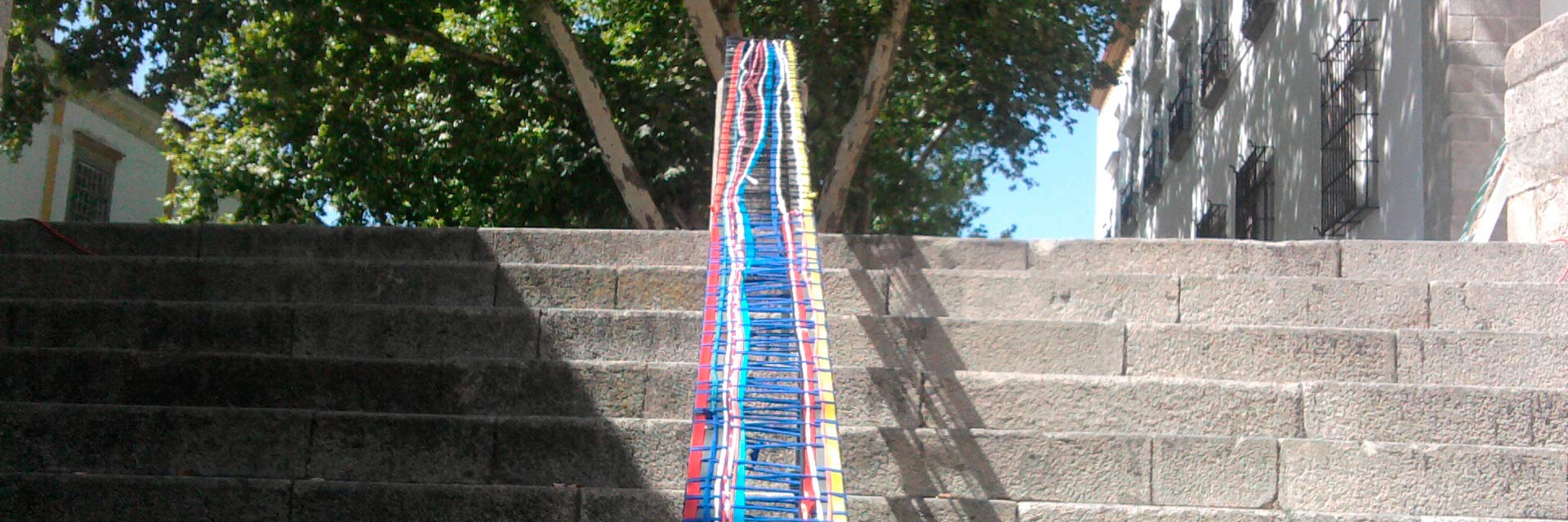 Stairs in the historic center with colorful ribbons on the handrail.