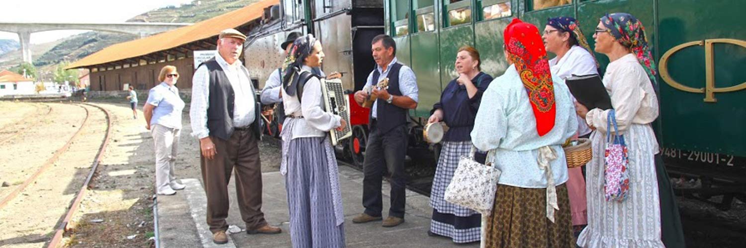 A folk dance troupe on the platform near one of the coaches.