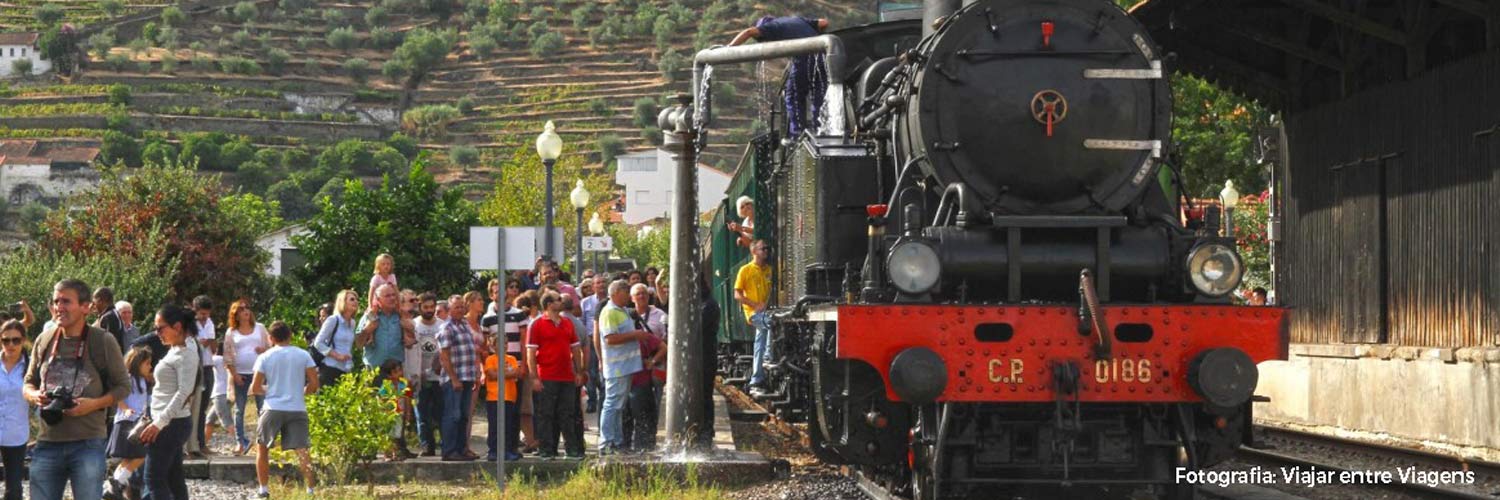 Passengers watch as the steam engine is filled with water.