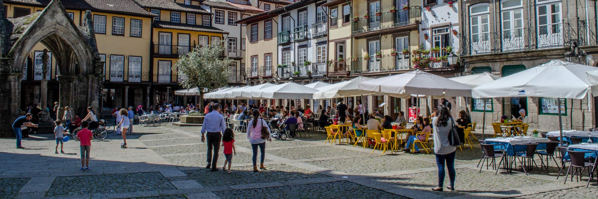 Largo da Oliveira in the historic centre, with its traditional houses, outdoor cafés and the Padrão de Nossa Senhora da Vitória.