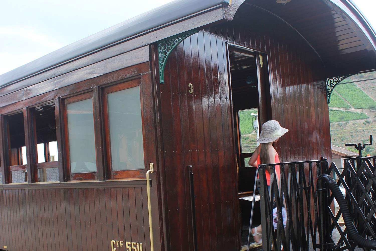 Historic carriage with number CTF 5511 with a small balcony, where there is a little girl wearing a hat.
