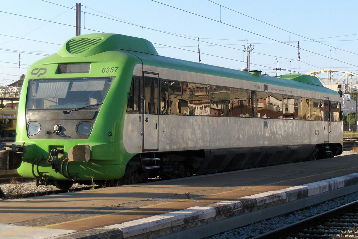 Diesel railcar from CP 0350 series with white and green livery, stopped at one of the station platforms.