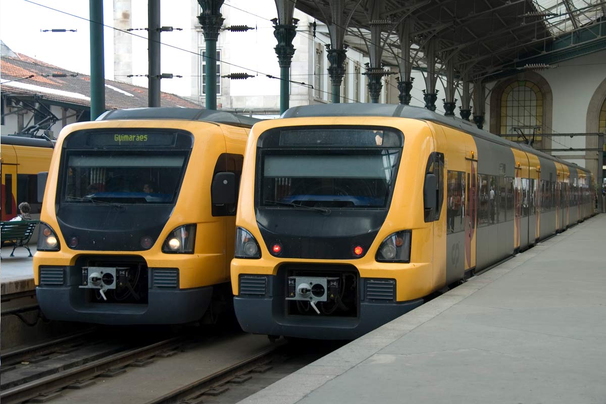 Automotoras elétricas da série CP 3400 cor amarelo e cinzento, parqueadas numa das plataformas da estação.