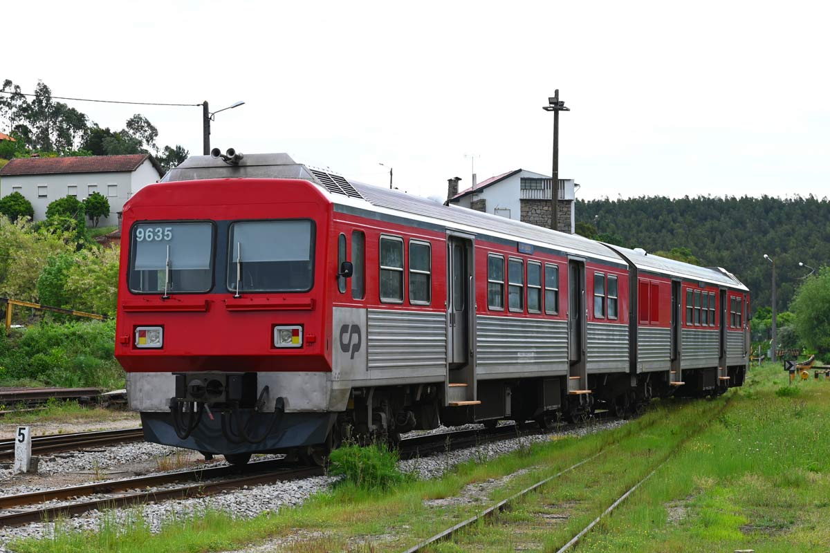 CP 9630 series metre-gauge diesel railcar with red and gray livery, parked on one of the station lines.