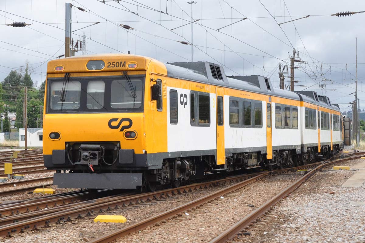 592 series diesel railcar with yellow, white and black livery arriving at the station.