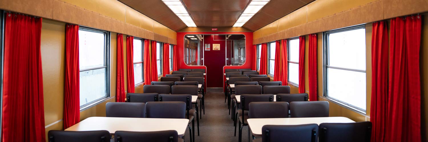 Interior of the Sorefame dining car with tables and chairs for meals.