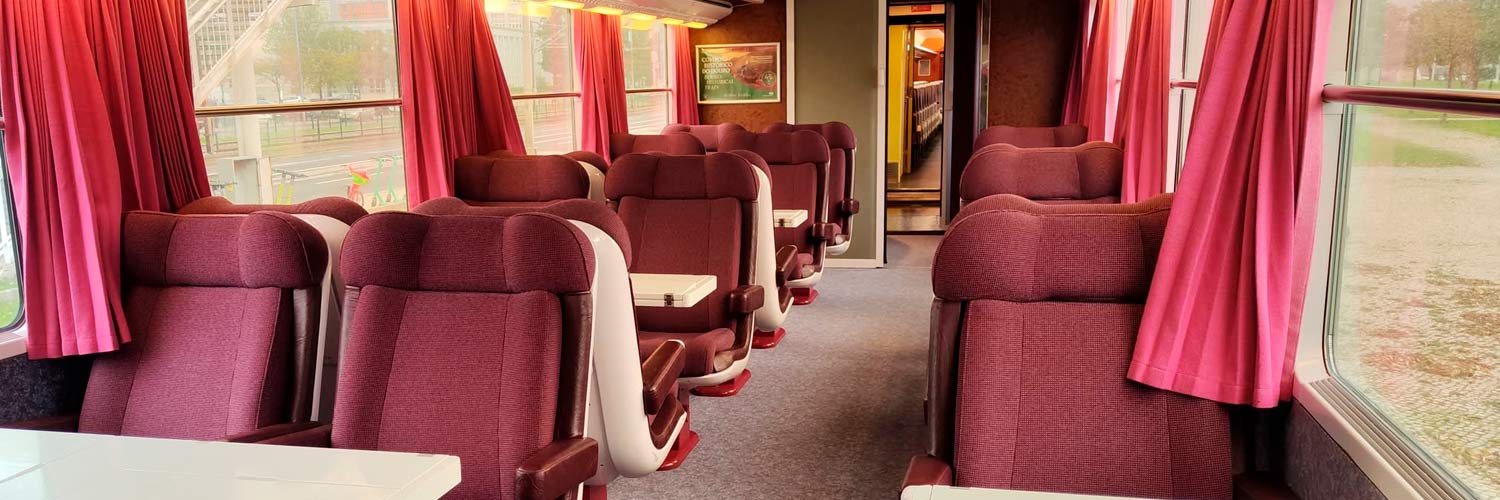 Interior of the VIP coach with seats and tables.