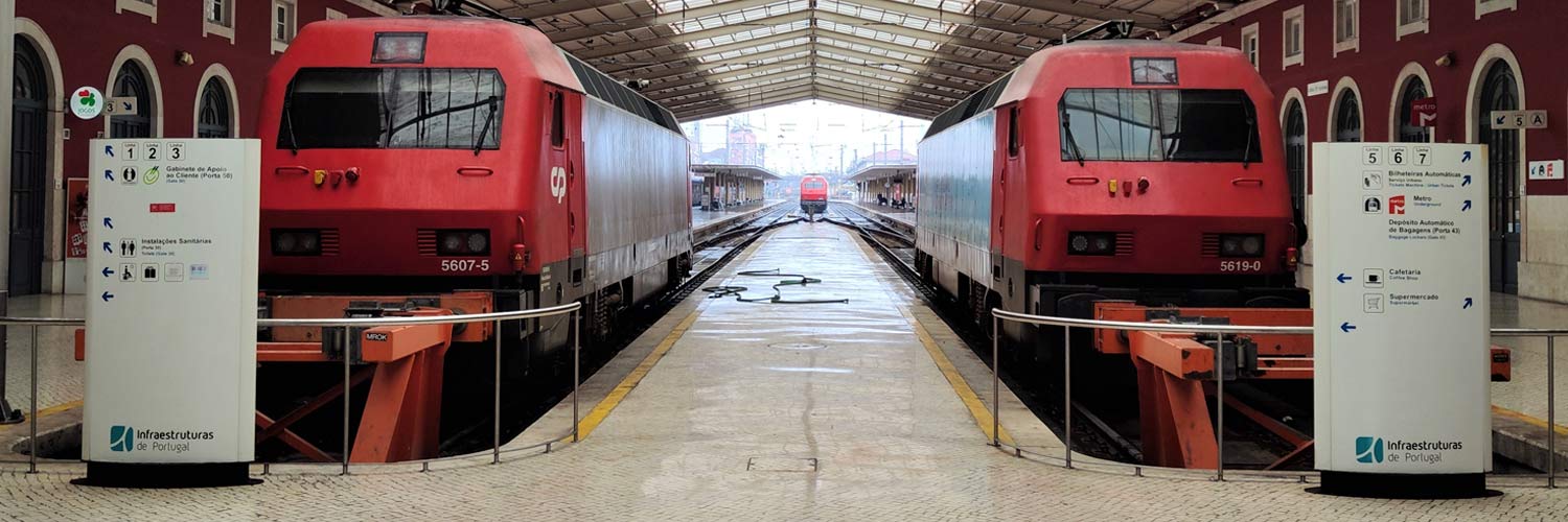 CP 5600 series electric locomotives with gray and red livery stopped at the rail platforms.