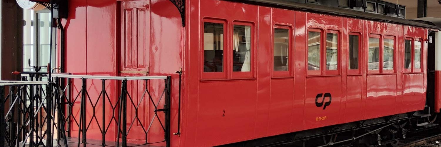 Aeyf 4116 narrow gauge passenger coach with red and white livery stopped at the station.