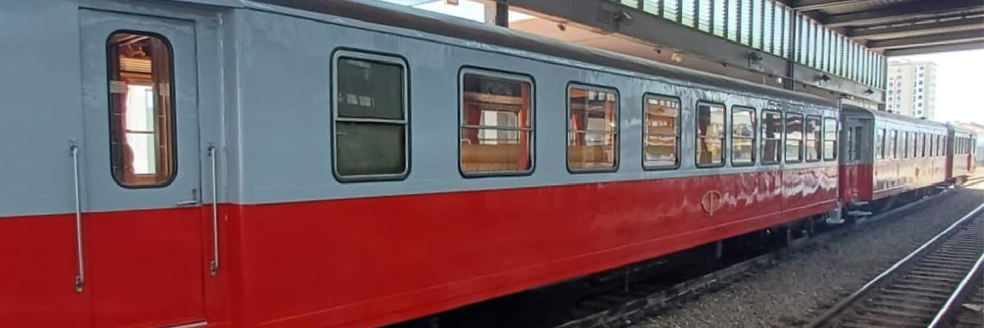 Carruagens ACEyf 36, AE 4syf 26 e Aeyf 26 cor vermelho, paradas na estação.