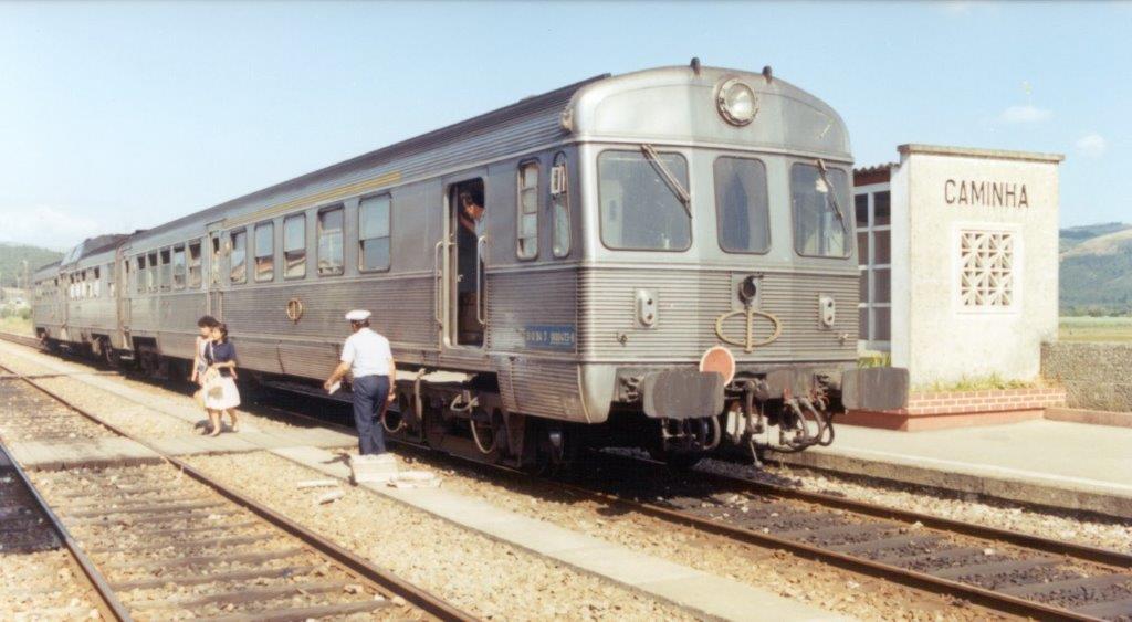 A CP 0400 series diesel multiple unit in Caminha, with three people standing by the train.