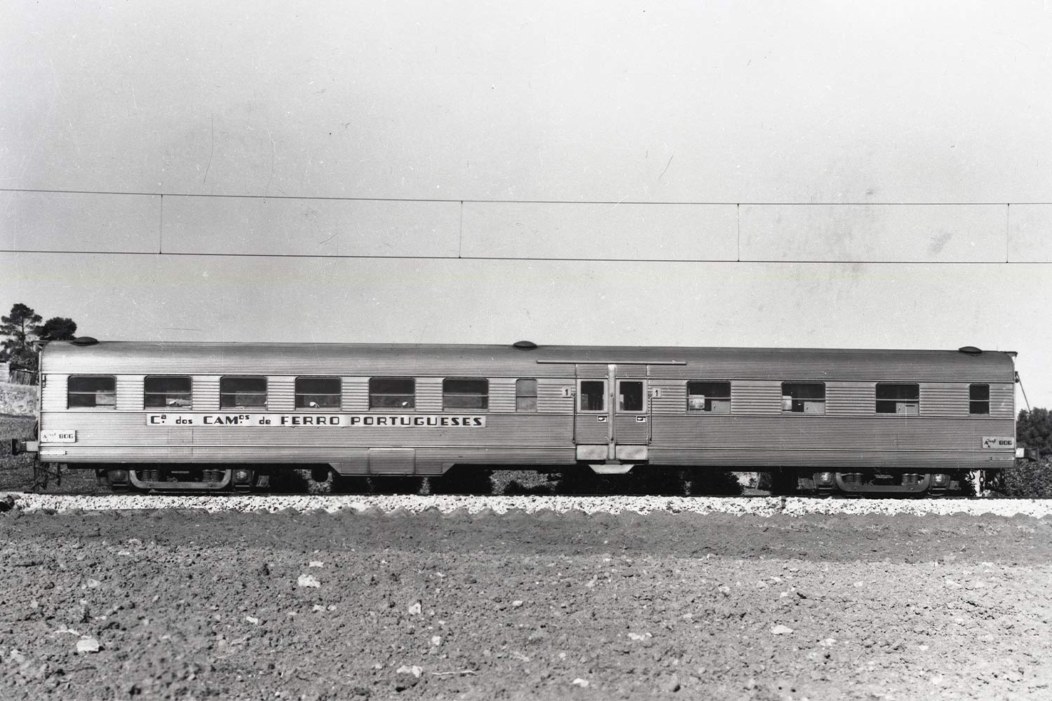 Carruagem Budd, cor cizento, parada numa das linhas da estação.