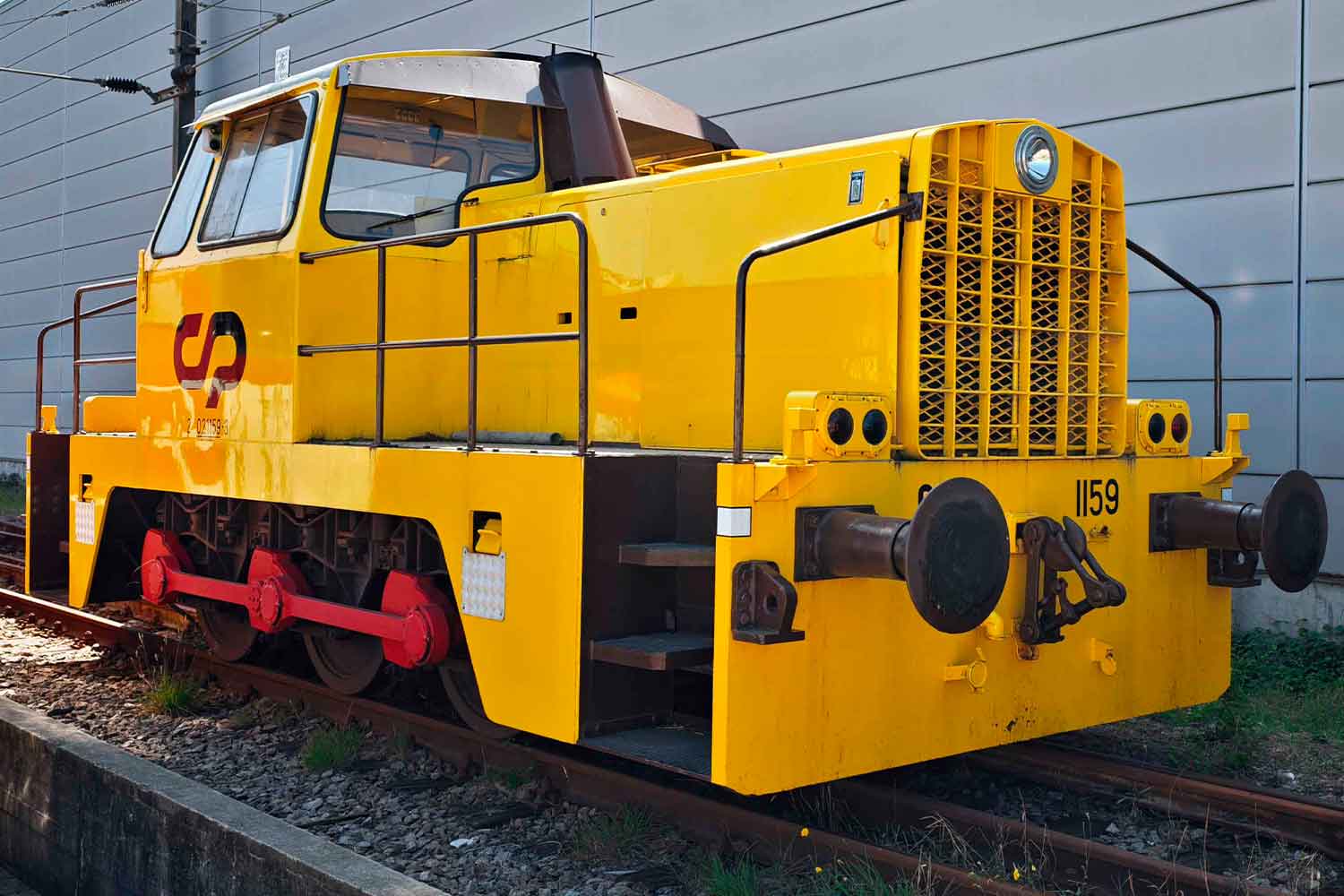 The CP 1159 diesel locomotive livery in shades of yellow, dark brown and red.