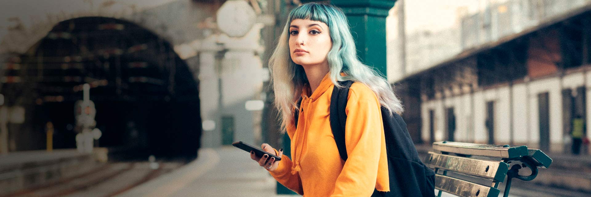 Jovem sentada em banco da Estação de Porto São Bento.
