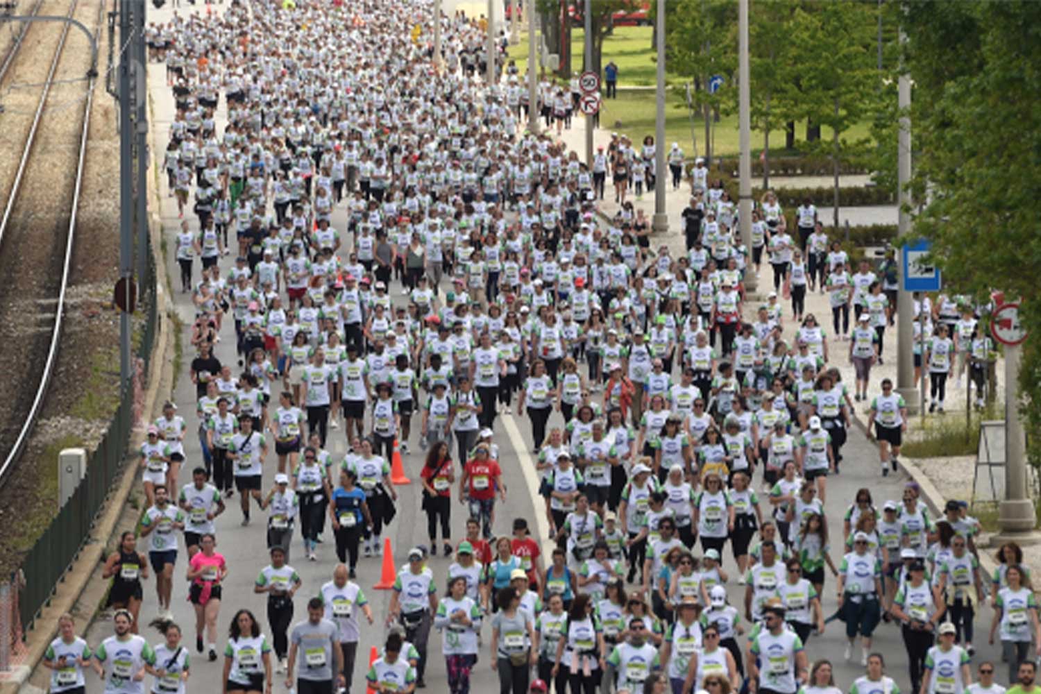 Imagem a cores de grupo de pessoas a correr ao lado da Linha de Cascais.