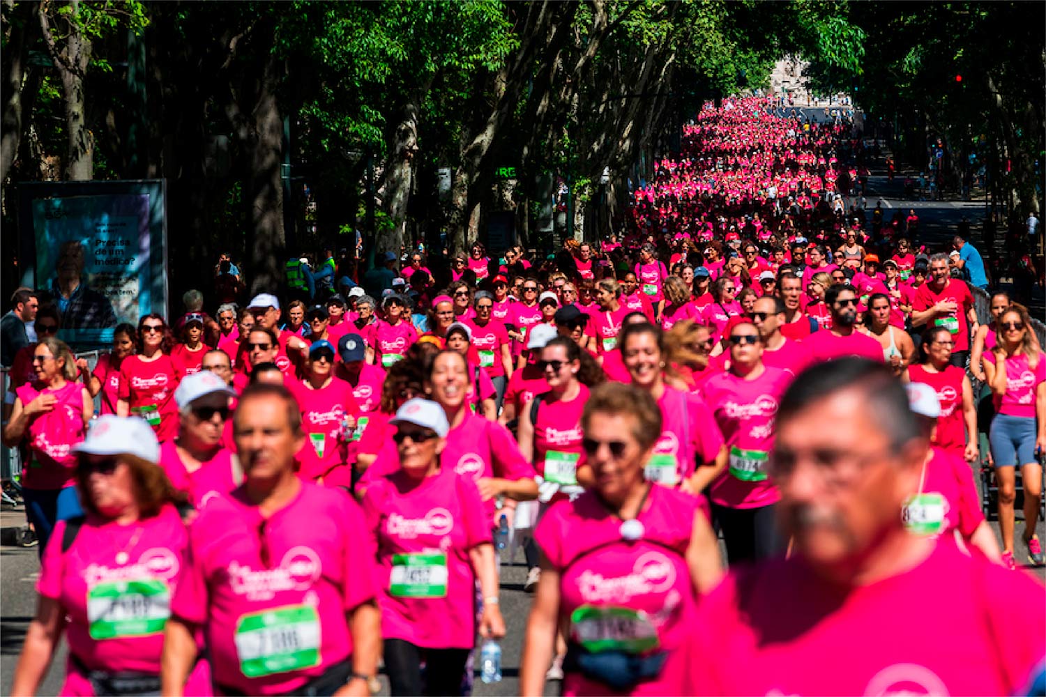 Pessoas com t-shirt cor de rosa a correr na rua.