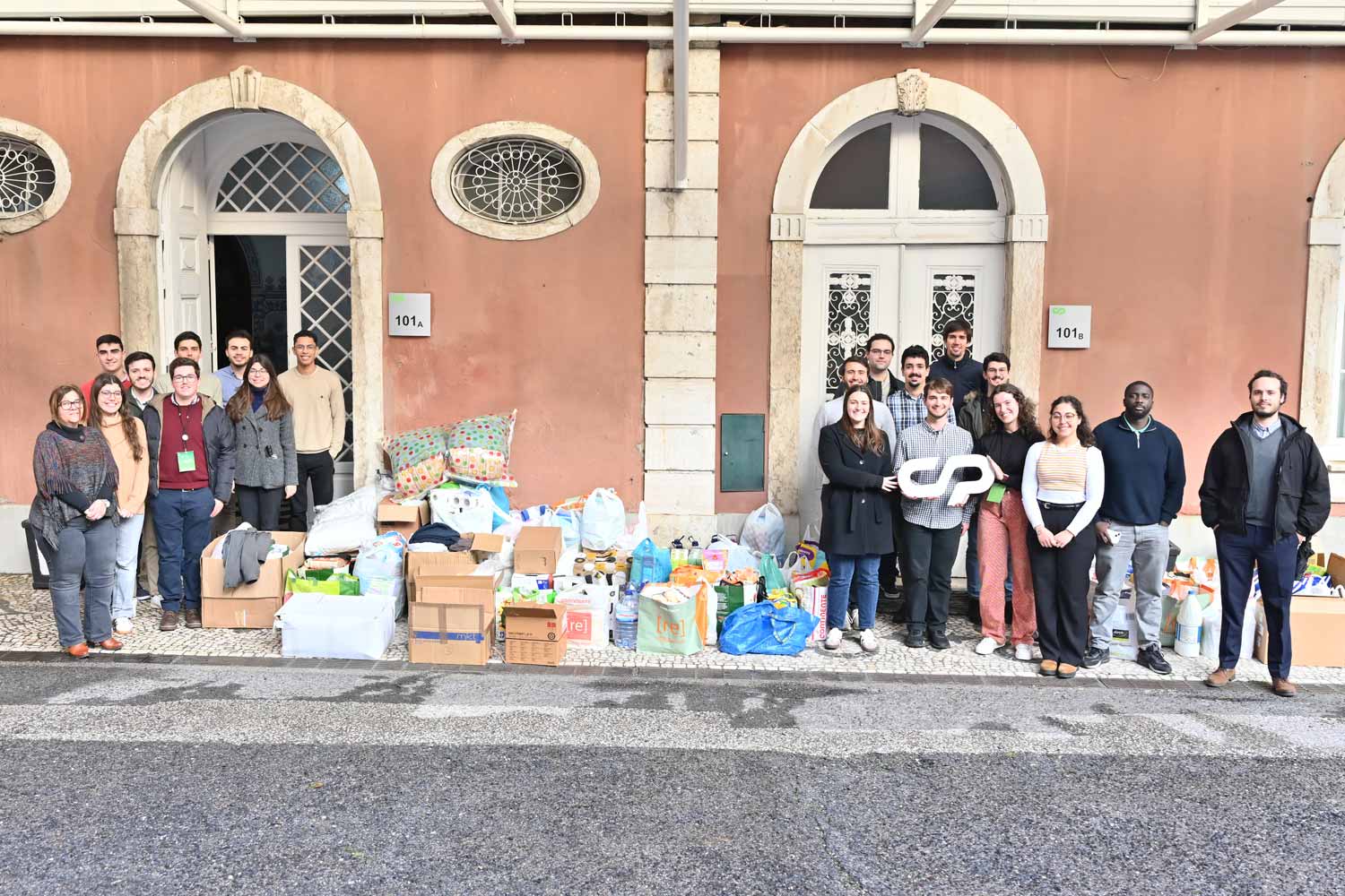 Young workers next to donated goods at the company entrance.