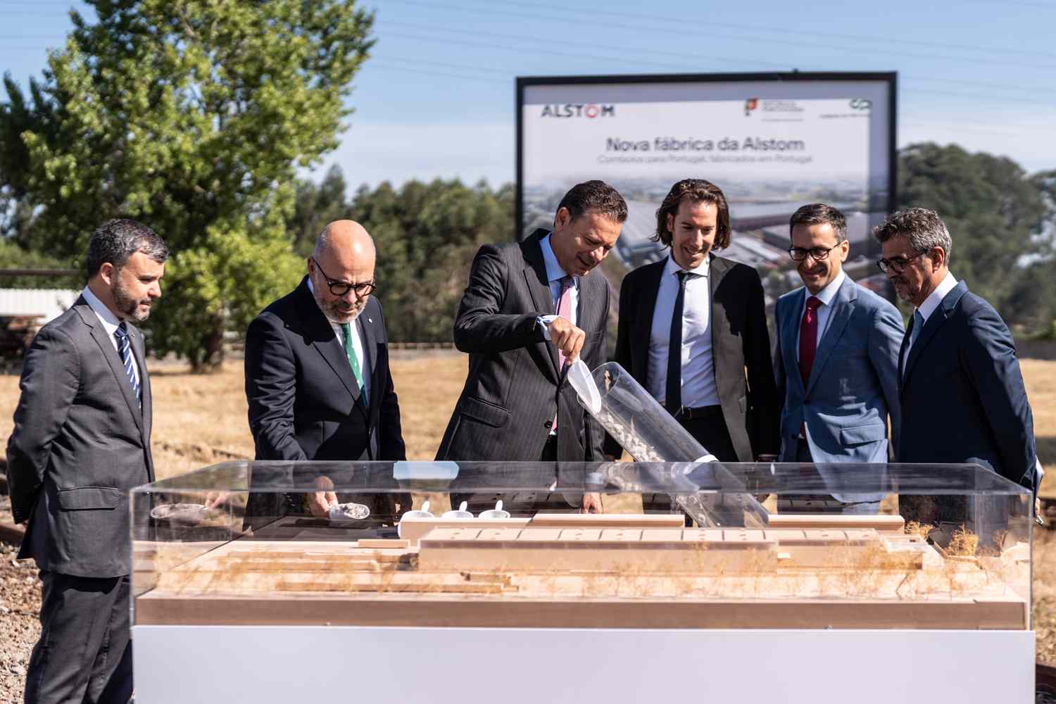 Grupo de pessoas, incluindo o Primeiro-Ministro e o Presidente da CP, na cerimónia de lançamento da primeira pedra da nova fábrica.