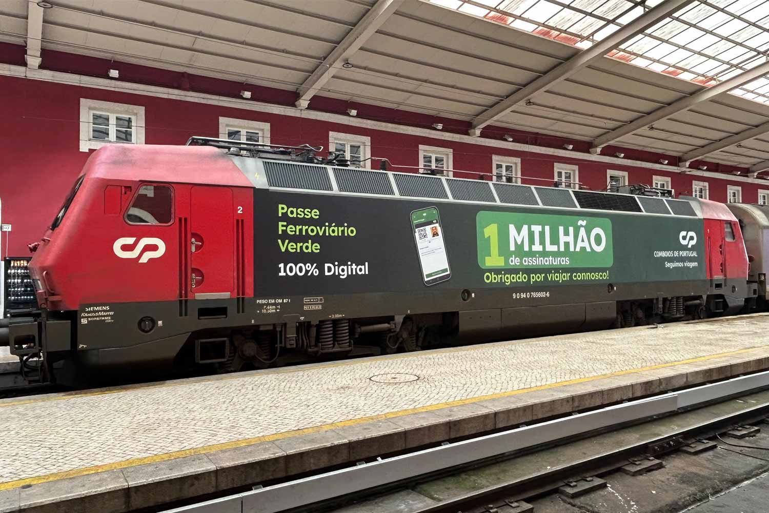 Locomotiva 5600 com vinil comemorativo, onde está escrito: Passe Ferroviário Verde 100% digital, 1 mihlão de assinaturas, Obrigado por viajar connosco.