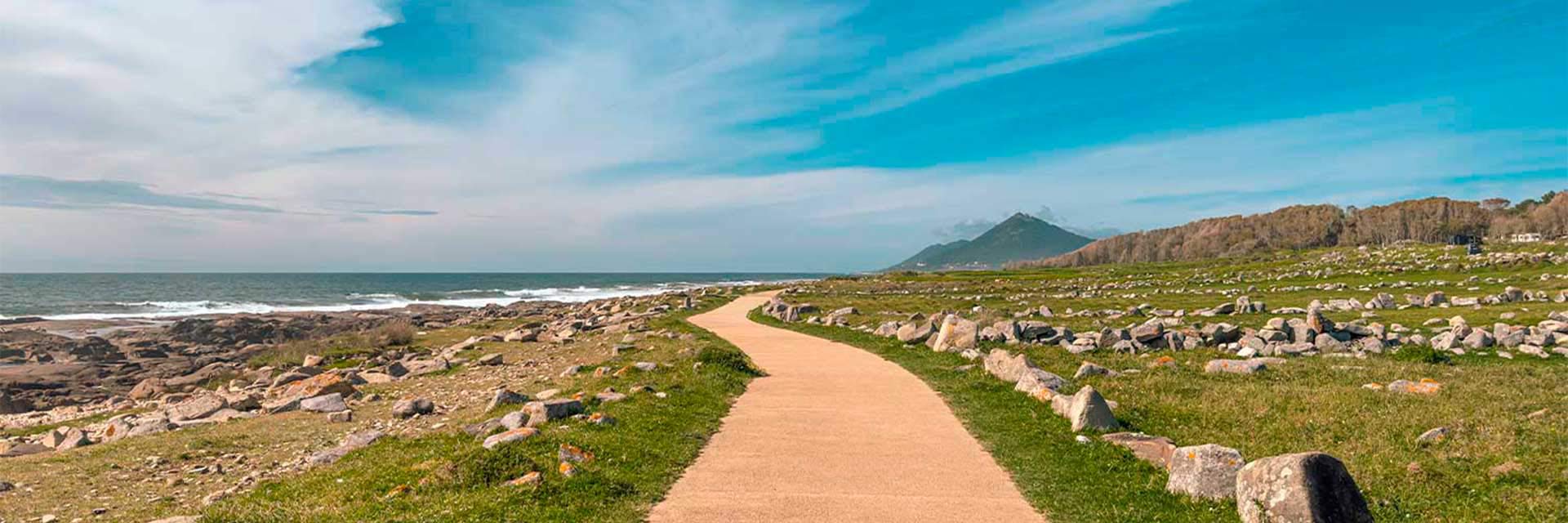 A cycle path by the sea and countryside, with grass and stones, in the Minho region.